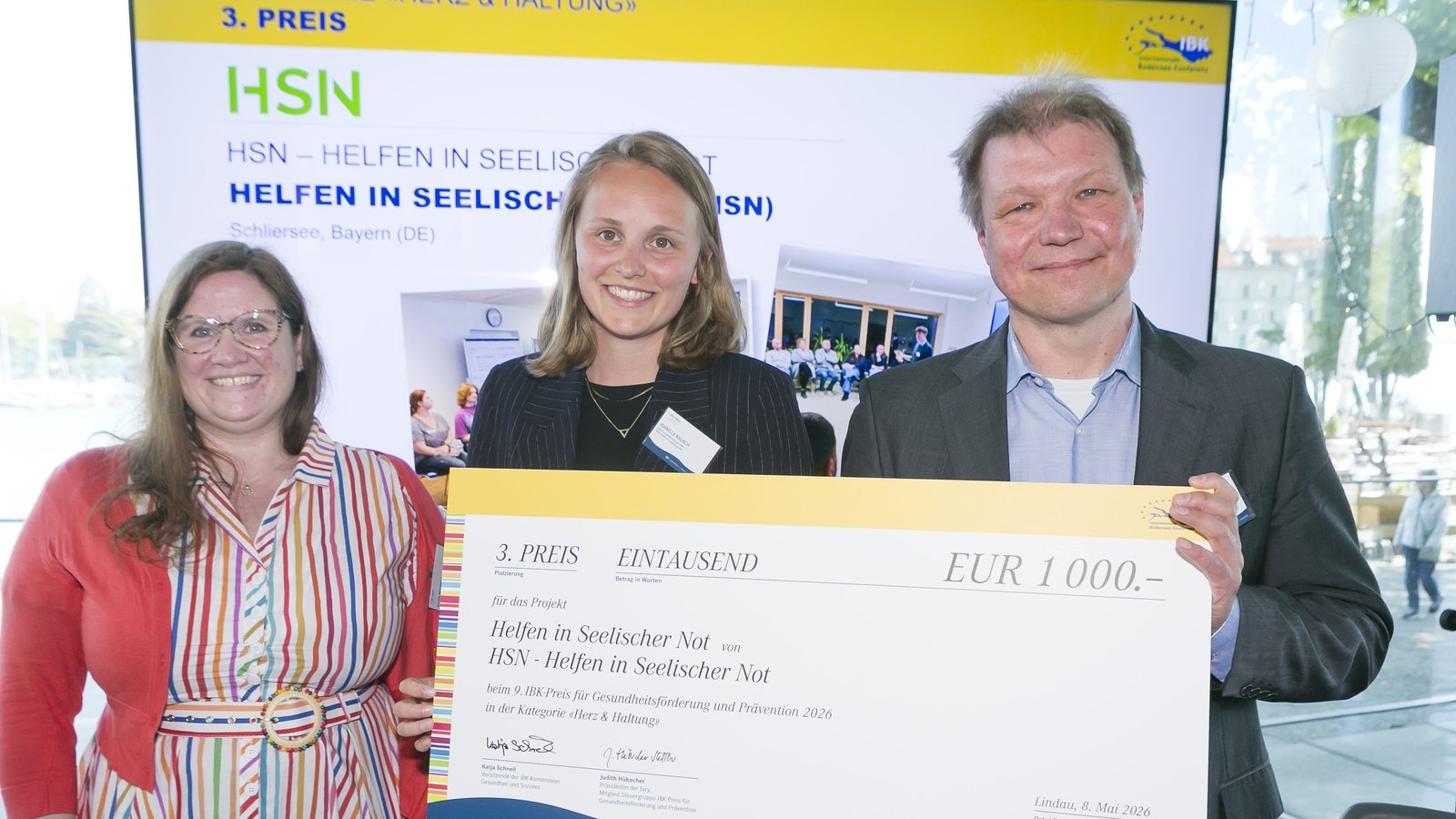 Übergabe des 3. Preises in der Kategorie „Herz & Haltung" des 9. IBK-Preises für Gesundheitsförderung und Prävention 2026 an Isabelle Rausch und Roger Schmidt von Helfen in Seelischer Not (HSN) durch Katja Schnell, Vorsitzende der IBK-Kommission Gesundheit und Soziales, Lindau, 8. Mai 2026